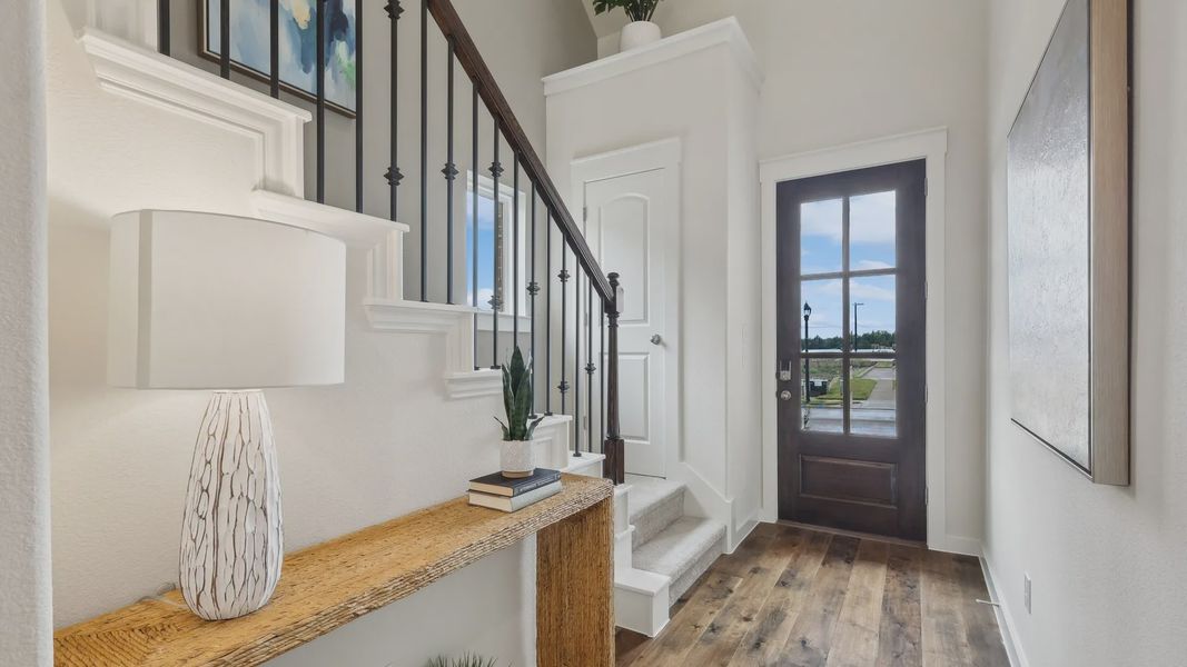 Luxurious Churchill entryway boasts rich wood floors, white stairway with wrought iron, and natural light. Luxurious Churchill entryway boasts rich wood floors, white stairway with wrought iron, and natural light.
