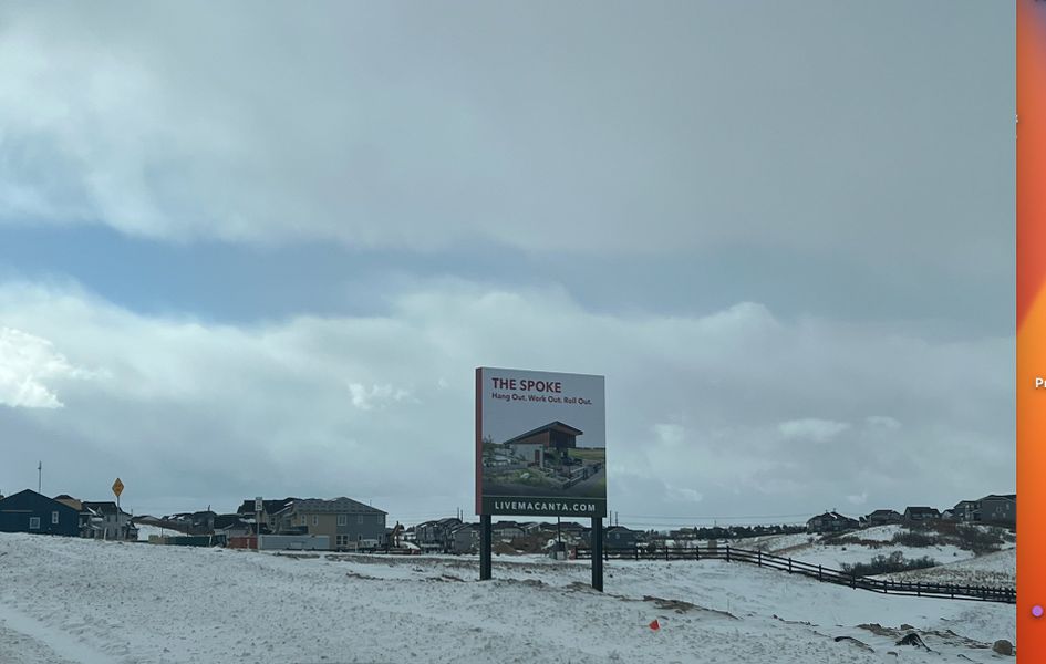 A serene snowy landscape with a community sign, showcasing Macanta: The Grand Collection by Lennar in Castle Rock, CO.