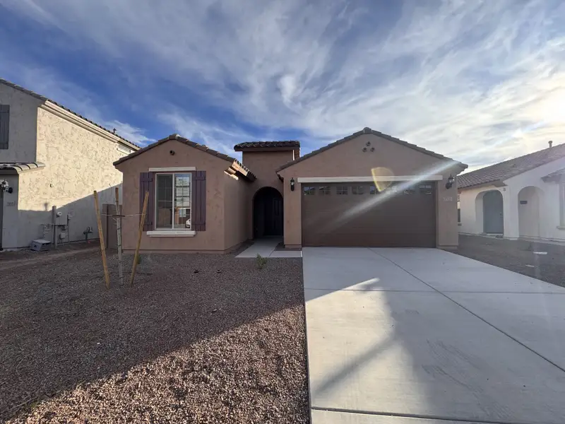 Charming stucco home with dark shutters and a spacious driveway in Aloravita by Pulte Homes, Peoria, AZ.