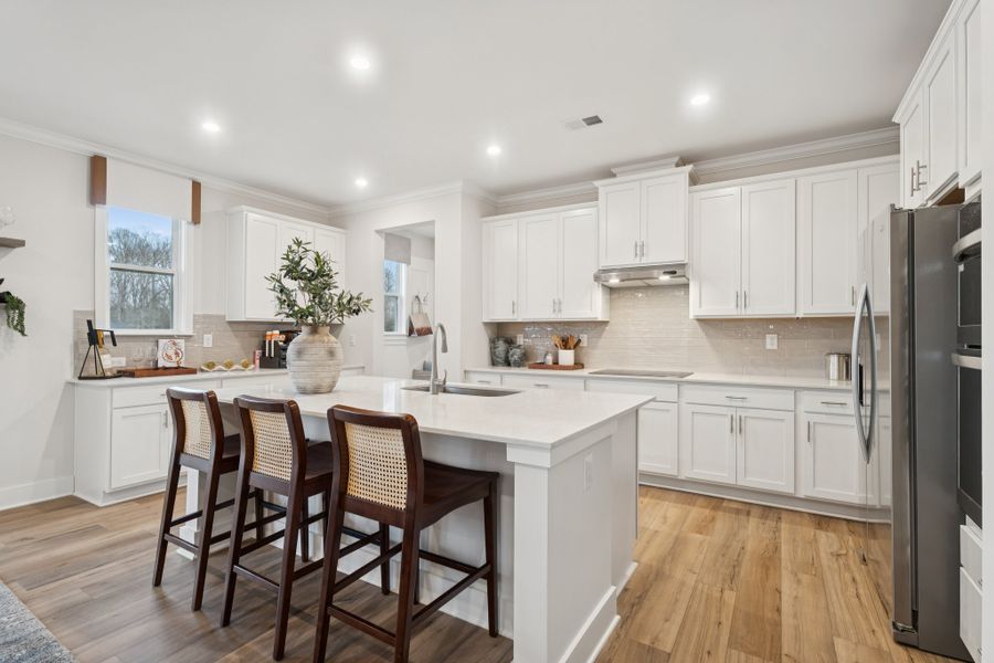 A kitchen with white cabinets.