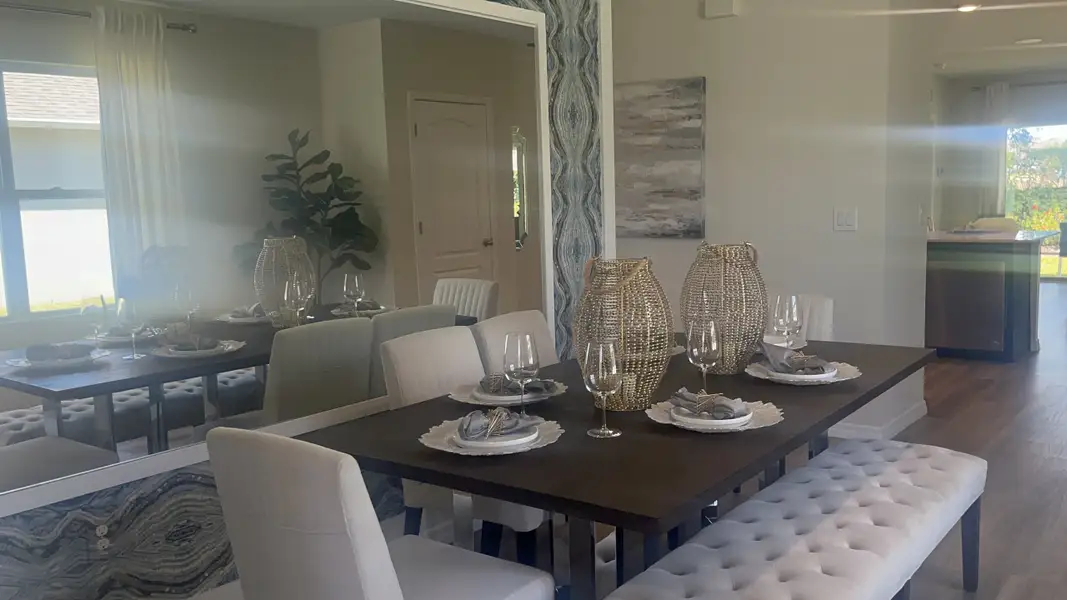 Elegant dining area with a sleek dark table, plush seating, decorative mirrors, and chic table settings.
