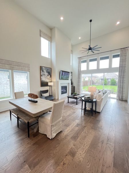 A spacious, open living area with high ceilings, elegant dining setup, and large windows overlooking a serene outdoor view. A spacious, open living area with high ceilings, elegant dining setup, and large windows overlooking a serene outdoor view.