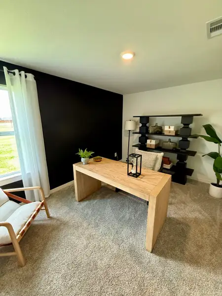 A cozy home office with a wooden desk, dark accent wall, and modern shelving, perfect for productivity.