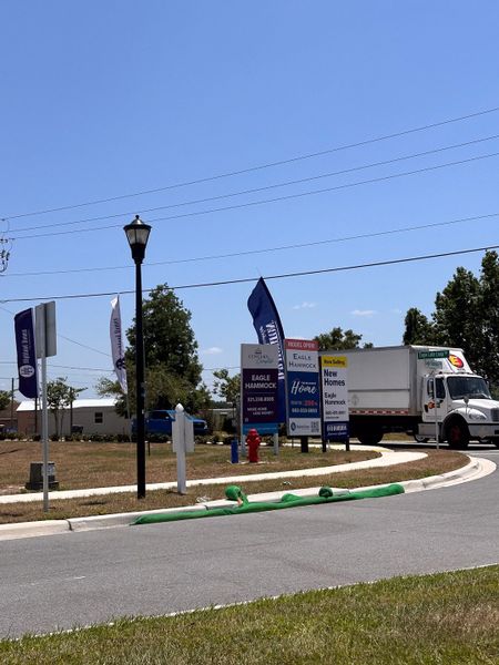 A vibrant new home community entrance in Eagle Hammock by D.R. Horton (Eagle Lake, FL), with welcoming signage and model homes nearby.
