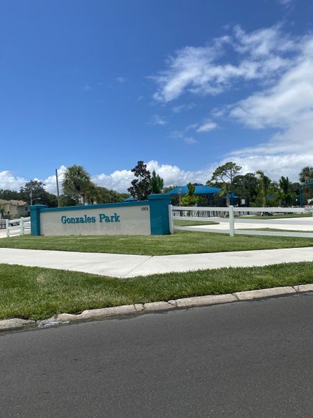 Vibrant community entrance for North Beach Townhomes by Dream Finders Homes in Jacksonville, FL, with lush greenery and sunny skies. Vibrant community entrance for North Beach Townhomes by Dream Finders Homes in Jacksonville, FL, with lush greenery and sunny skies.