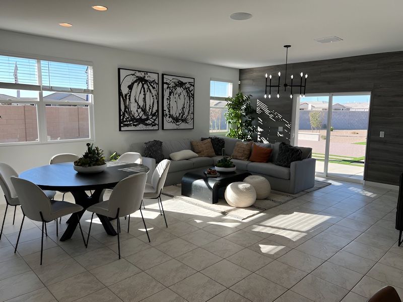 A spacious living area with modern decor, featuring a cozy sectional, round dining table, and ample natural light. A spacious living area with modern decor, featuring a cozy sectional, round dining table, and ample natural light.