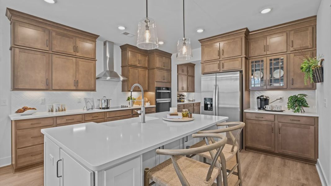 Two story home in Woodruff, SC with spacious kitchen with wooden cabinetry and large island at Pinebrook by DRB Homes Two story home in Woodruff, SC with spacious kitchen with wooden cabinetry and large island at Pinebrook by DRB Homes