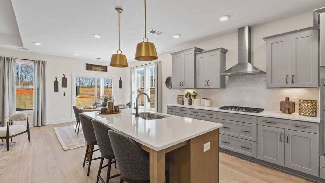 Luxury kitchen with gold accents, modern appliances, and wooden island at Magnolia Park by DRB Homes in Woodruff, SC Luxury kitchen with gold accents, modern appliances, and wooden island at Magnolia Park by DRB Homes in Woodruff, SC