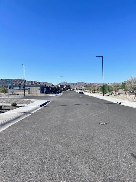 A serene street view in Village at Sundance by Centex with mountain backdrop, Buckeye, AZ. A serene street view in Village at Sundance by Centex with mountain backdrop, Buckeye, AZ.