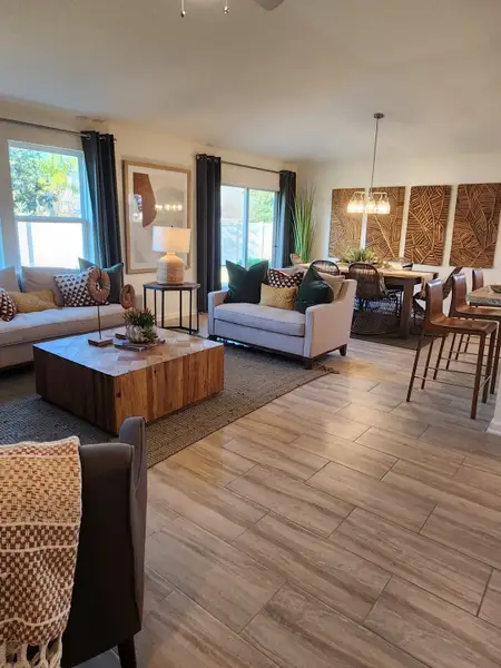 An inviting open-concept living and dining space with earthy tones and natural textures in Panther Creek by KB Home (Jacksonville, FL).