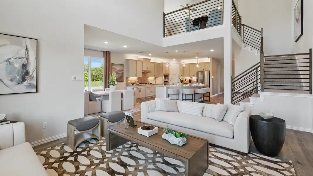Spacious living area with open sightlines to the kitchen, dining space, and second-floor game room. Spacious living area with open sightlines to the kitchen, dining space, and second-floor game room.