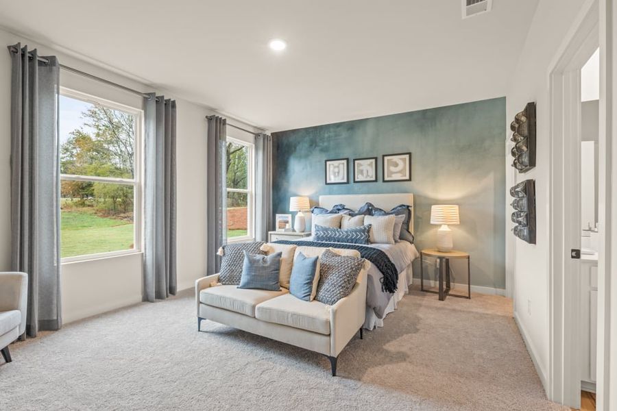 A room with a couch and a window with a view of the yard.