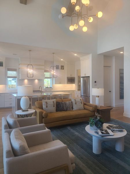 A modern living area with an open kitchen, plush seating, and elegant lighting. Perfect for relaxed gatherings.