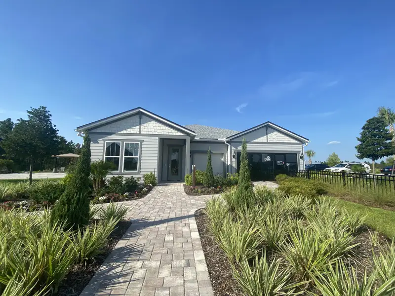 Charming gray home with manicured landscaping in The Landings at Saint Johns by Pulte Homes (St. Johns, FL).
