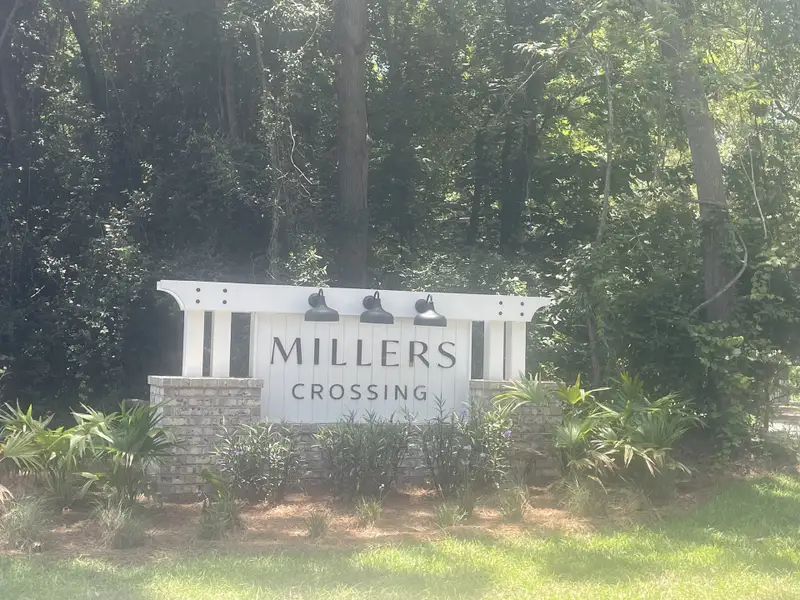 A welcoming entrance to Miller's Crossing by Dream Finders Homes, surrounded by lush greenery in Johns Island, SC.