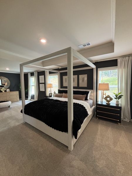 A luxurious bedroom with a chic four-poster bed, plush bedding, and modern decor accents.