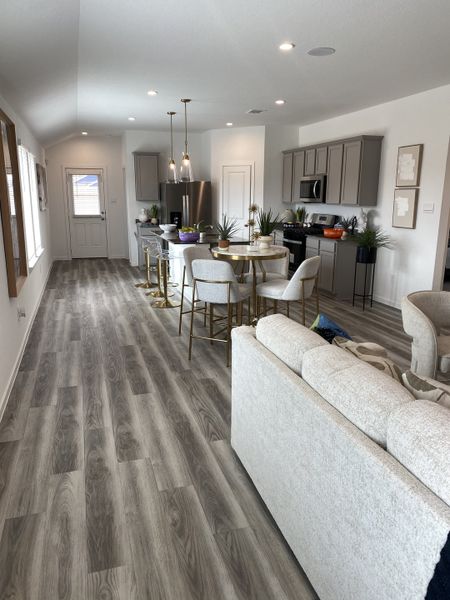 A bright, airy living space with a contemporary kitchen, dining area, and cozy seating nook.