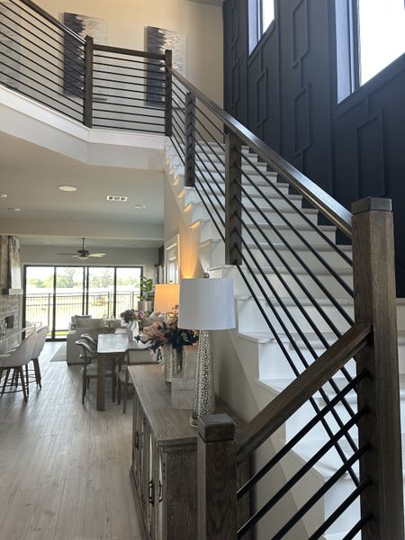 A modern interior with sleek staircase, open dining area, and elegant decor.
