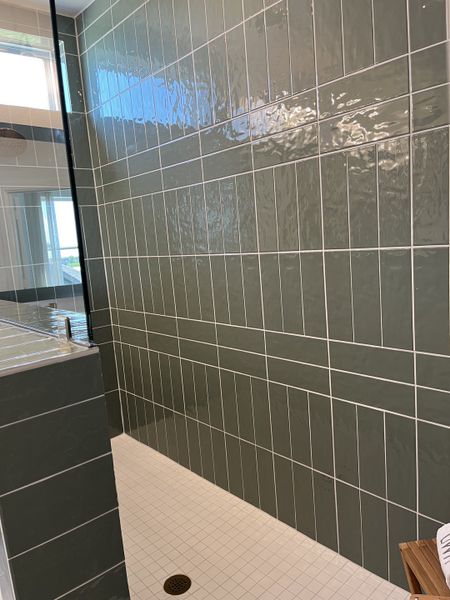 A sleek bathroom with glossy green tiles and a minimalist shower space. A sleek bathroom with glossy green tiles and a minimalist shower space.