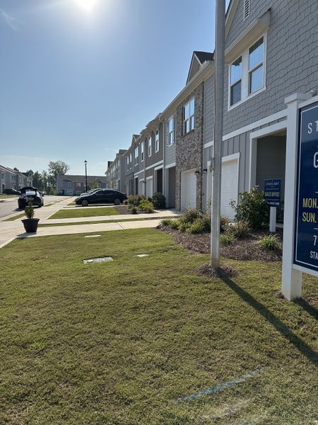 A beautiful row of townhouses in Greyson Parc by Starlight Homes, featuring modern exteriors, in Locust Grove, GA.
