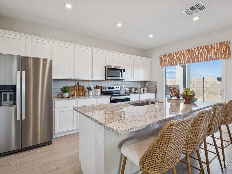 A kitchen with white cabinets.