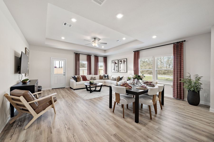 A large living room with a large dining table and chairs. A large living room with a large dining table and chairs.