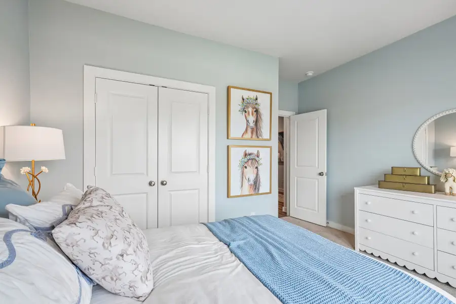A bedroom with a bed and a mirror.
