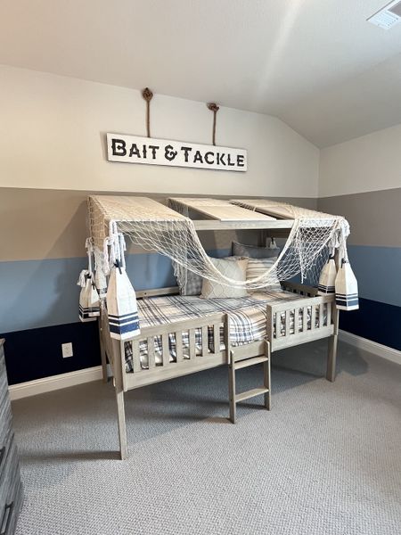 A nautical-themed kids' room with a unique bed, fishing net accents, and marine decor creating a cozy, adventurous vibe. A nautical-themed kids' room with a unique bed, fishing net accents, and marine decor creating a cozy, adventurous vibe.