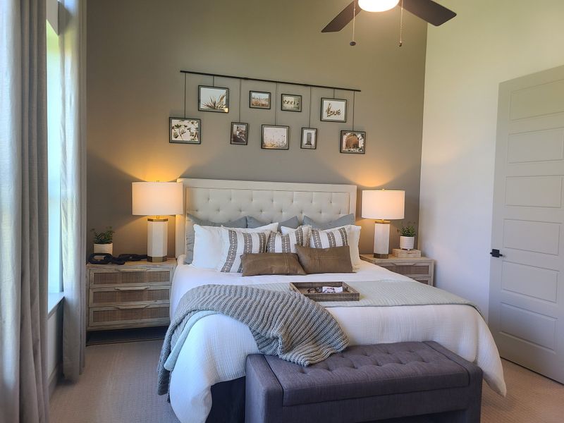 A cozy bedroom featuring a tufted headboard, elegant lighting, and decorative wall art for a serene ambiance.
