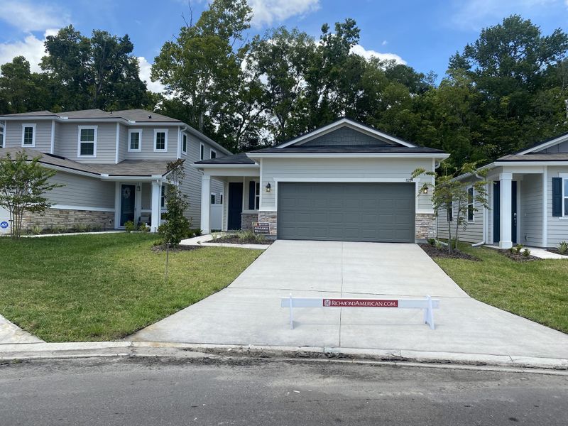 A modern gray home with a spacious driveway and lush yard in Seasons at Marietta Cove by Richmond American Homes (Jacksonville, FL).