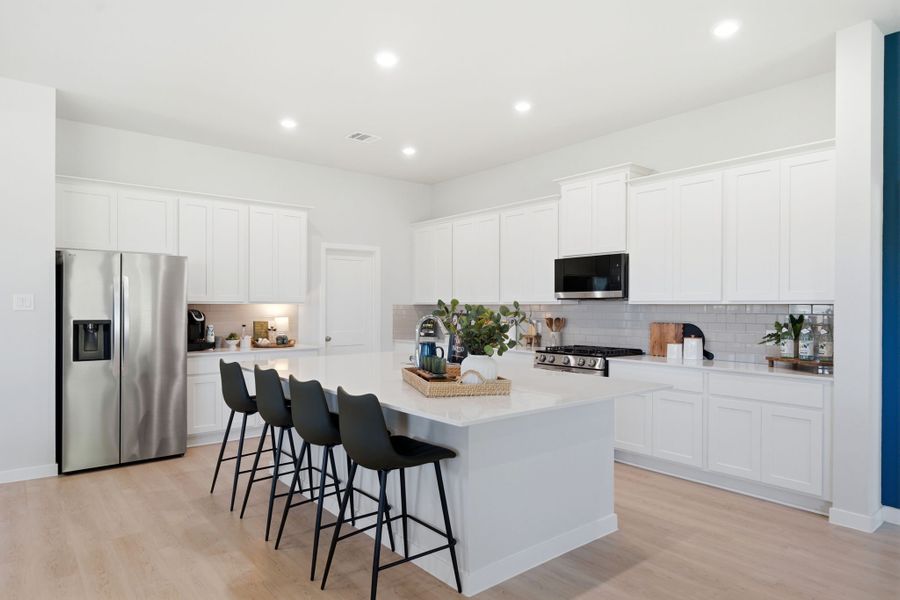 A kitchen with white cabinets.