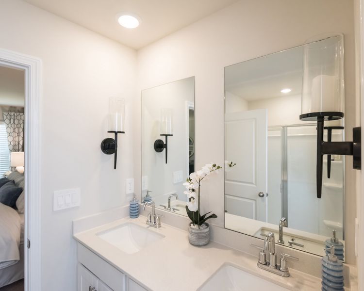 The primary bath features dual-vanity sinks and ample counter space.