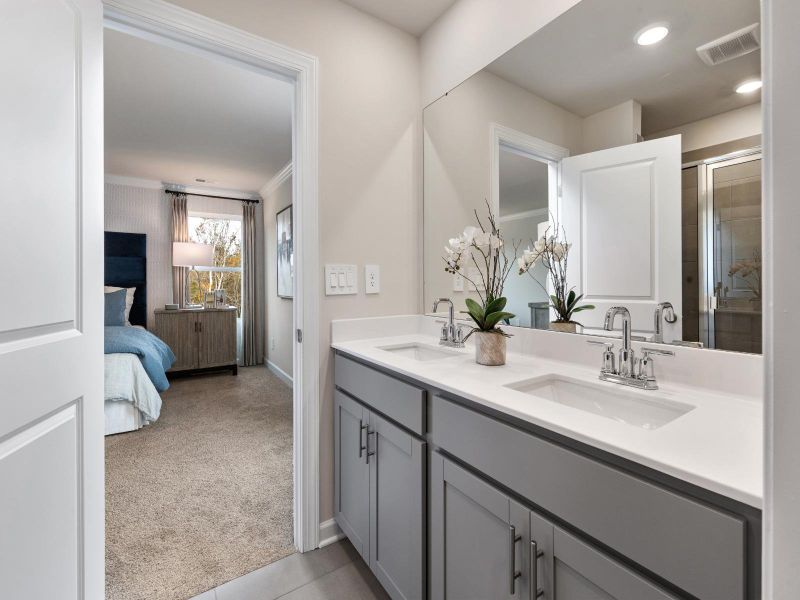 Primary bathroom with double vanity and large walk-in closet.