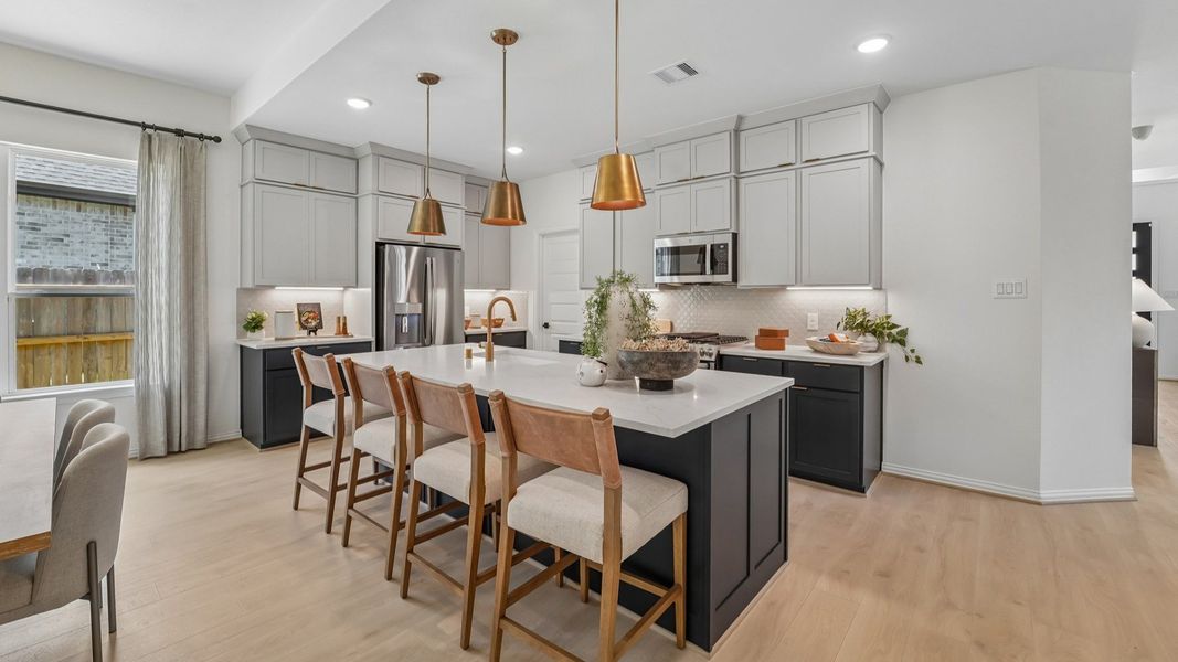 Elegant kitchen with quartz countertops, luxe pendant lighting, and custom cabinetry in The Woodlands Hills.
