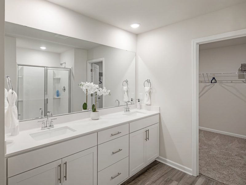 Dual vanities and a walk-in shower outfit the primary bathroom.