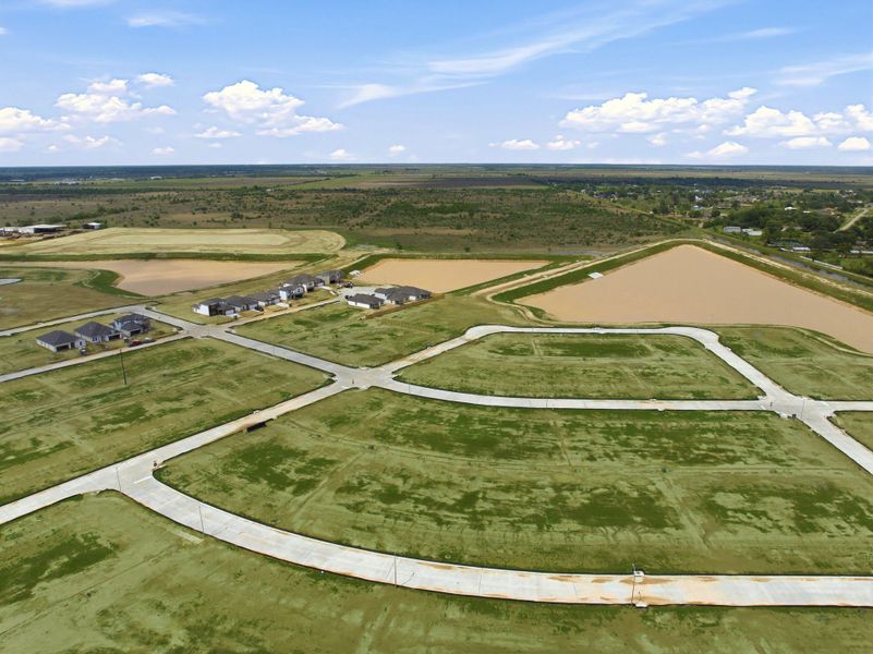 A large field with a few buildings.