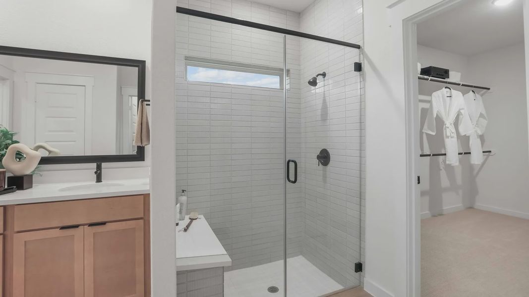 Elegant glass shower, sleek wood vanity, and expansive mirror enhance this Mostyn Springs sanctuary. Elegant glass shower, sleek wood vanity, and expansive mirror enhance this Mostyn Springs sanctuary.