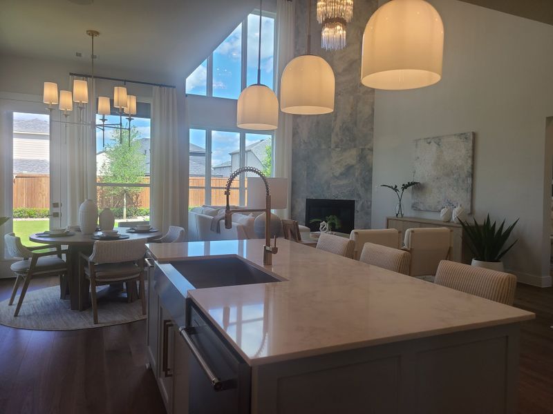 An elegant open-concept living space with vaulted ceilings, a chic dining area, and modern pendant lighting.