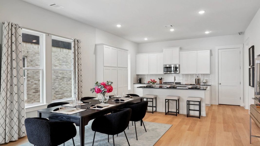 Luxurious Collin Creek kitchen with sleek white cabinetry and warm hardwood floors. Luxurious Collin Creek kitchen with sleek white cabinetry and warm hardwood floors.
