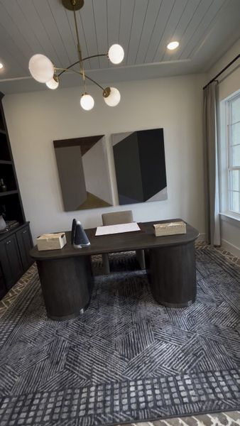 A contemporary home office featuring abstract art, a sleek desk, ambient lighting, and a patterned rug. A contemporary home office featuring abstract art, a sleek desk, ambient lighting, and a patterned rug.