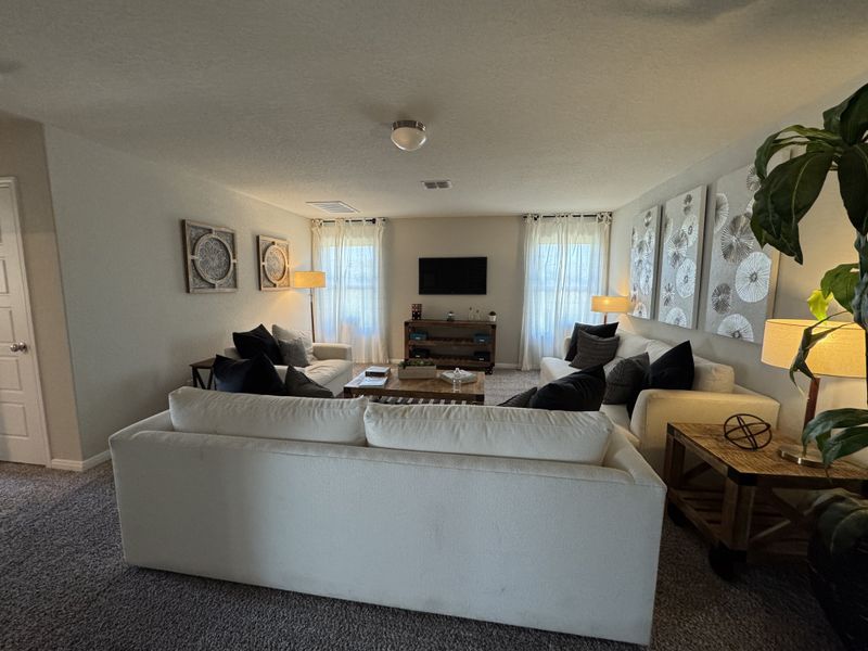 A cozy living room with plush sofas, abstract wall art, and warm lighting, offering a comfortable and inviting atmosphere.