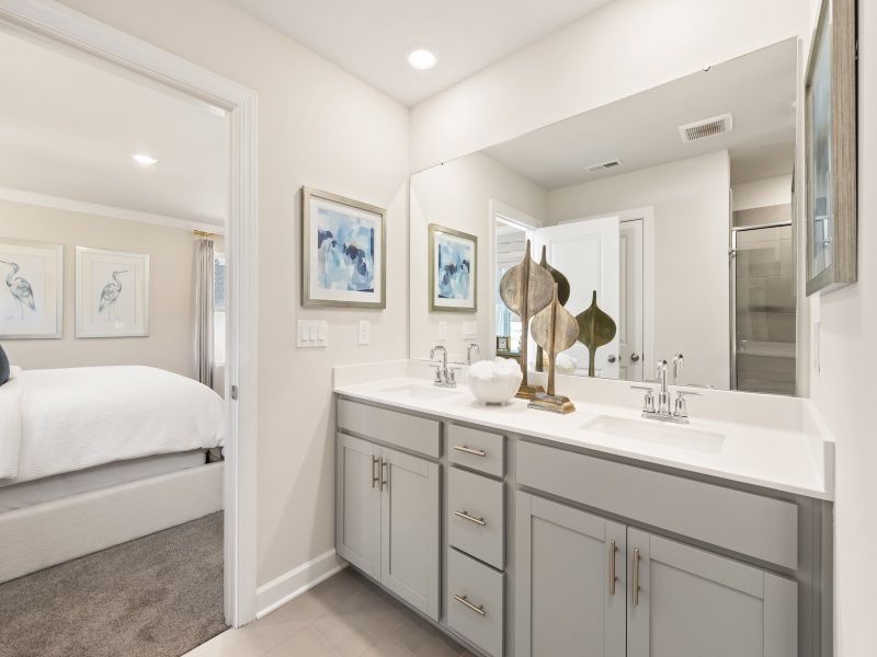 The ensuite bathroom features dual-vanity sinks and a walk-in closet.