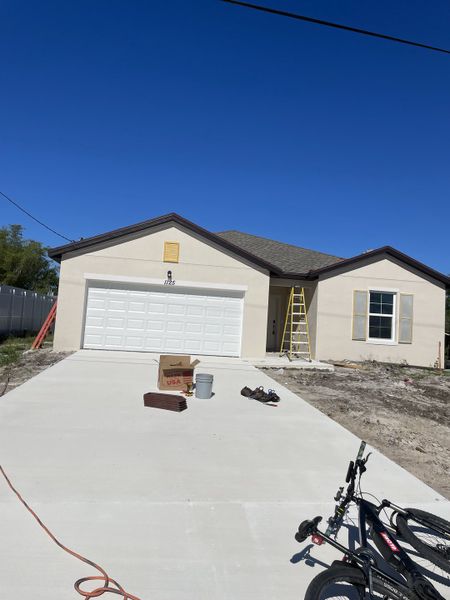 A modern beige home with a two-car garage situated in Aspire at Port St. Lucie by K. Hovnanian® Homes (Port St. Lucie, FL).