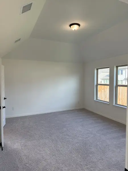 A spacious, well-lit room with plush carpet, white walls, and a modern ceiling light fixture. A spacious, well-lit room with plush carpet, white walls, and a modern ceiling light fixture.