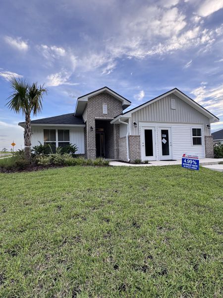 Charming brick and siding home with lush lawn in Shadow Crest at Rolling Hills by Adams Homes (Green Cove Springs, FL).