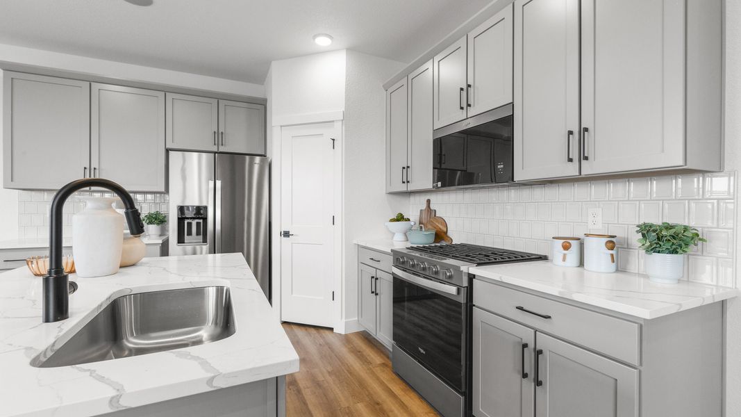 Exquisite marble countertops and sleek gray cabinetry define this elegant urban kitchen.