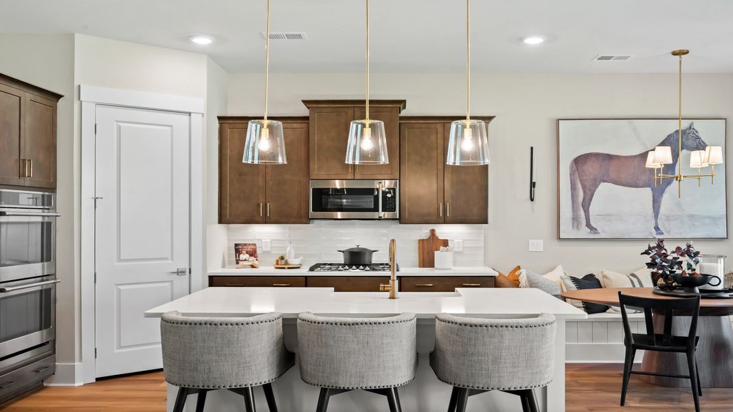 The Traveler kitchen features a spacious island, quartz countertops, and stylish 42" cabinets.