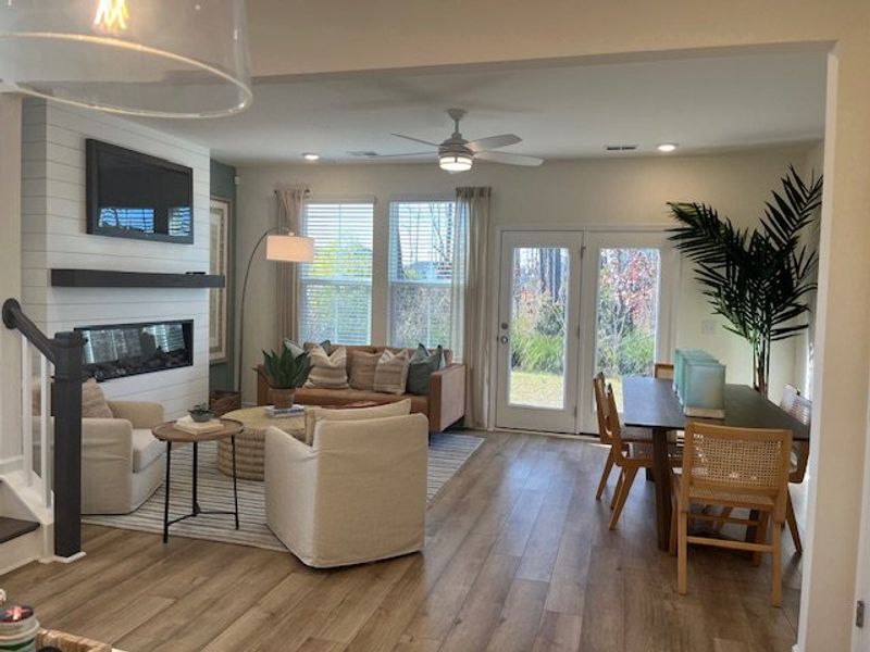 An inviting living-dining space with modern furniture, wooden flooring, and abundant natural light.
