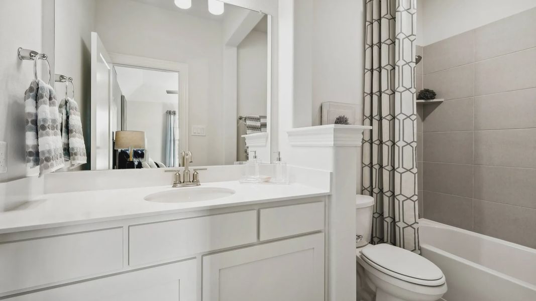 Elegant white vanity and chic geometric shower curtain in a Ridge Crossing residence. Elegant white vanity and chic geometric shower curtain in a Ridge Crossing residence.
