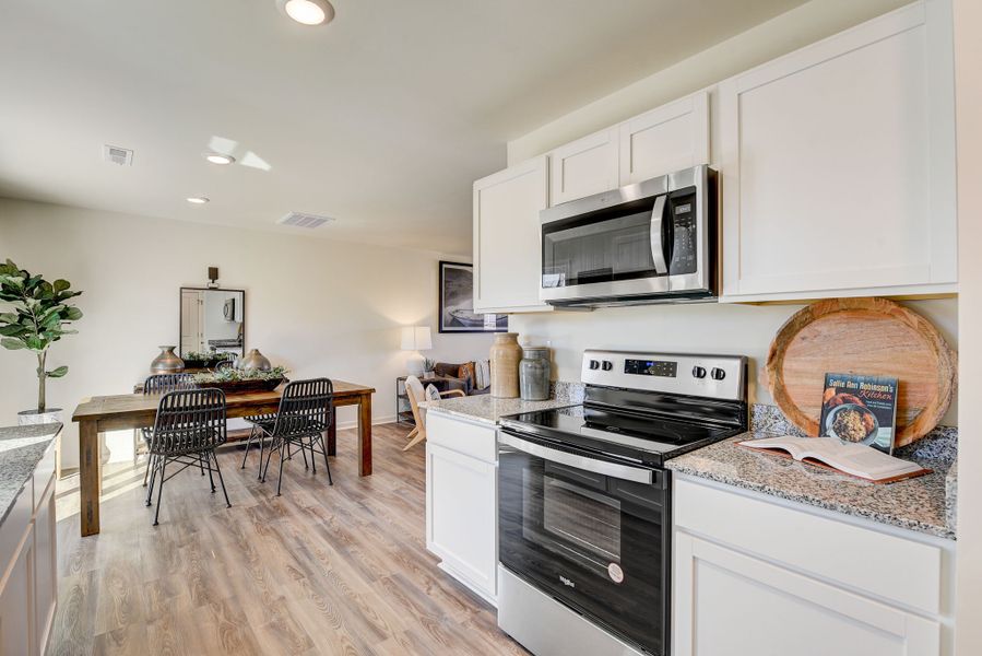 A kitchen with white cabinets.
